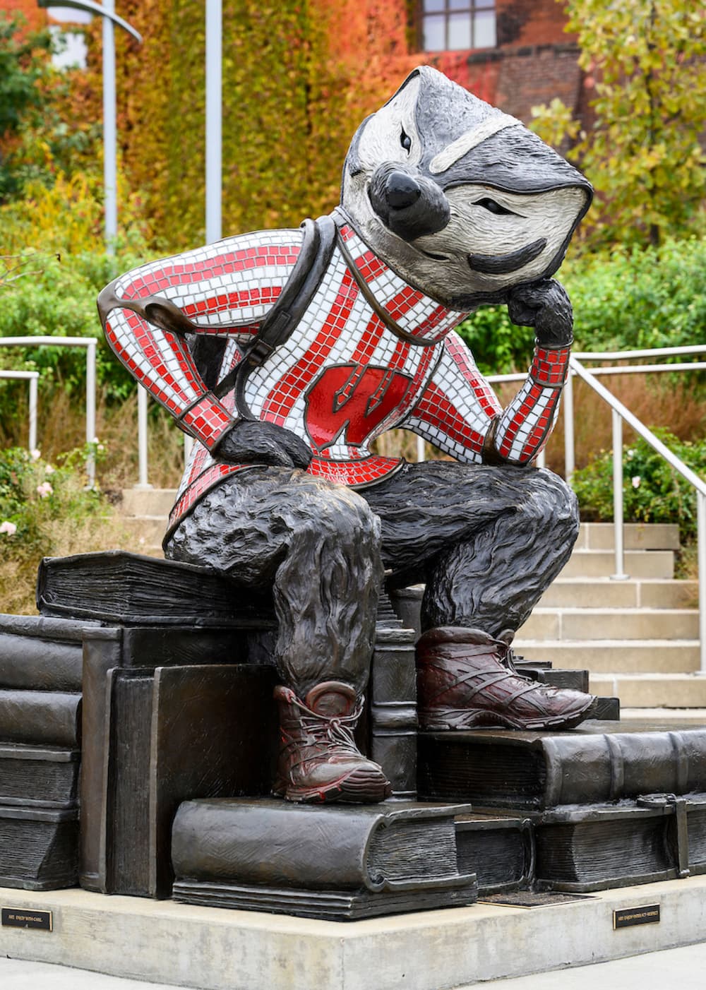 Statue of Bucky Badger sitting on a stack of books